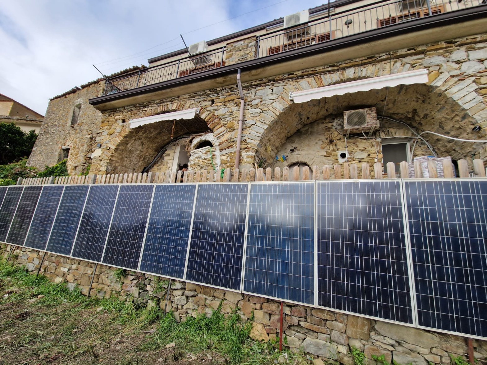 Vertical solar panels with a stone building in the background